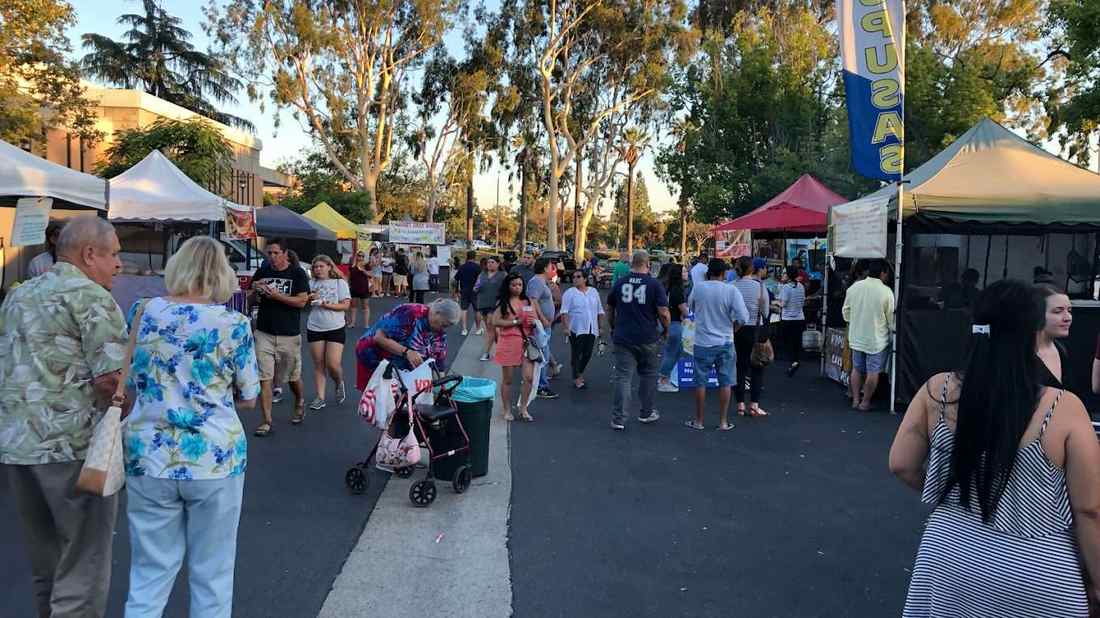 Shoppers browsing fruit and vegetables at an outdoor market