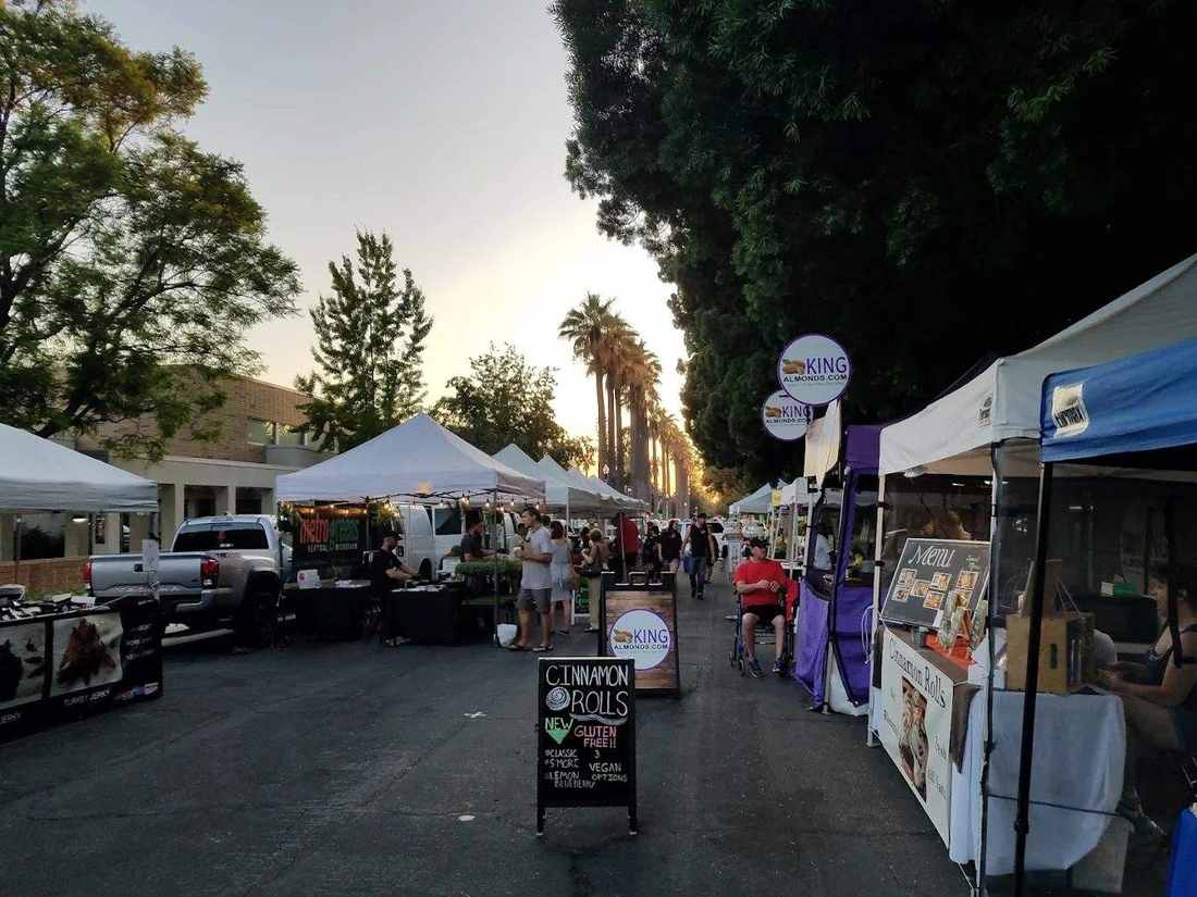 Market tents along an aisle in warm evening light